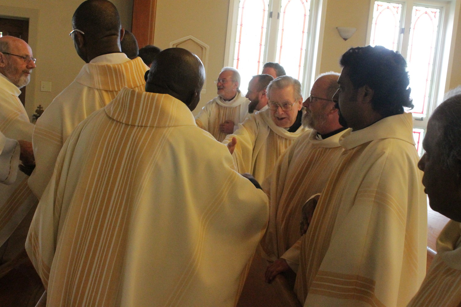 Priests exchange a sign of peace during the Mass.
